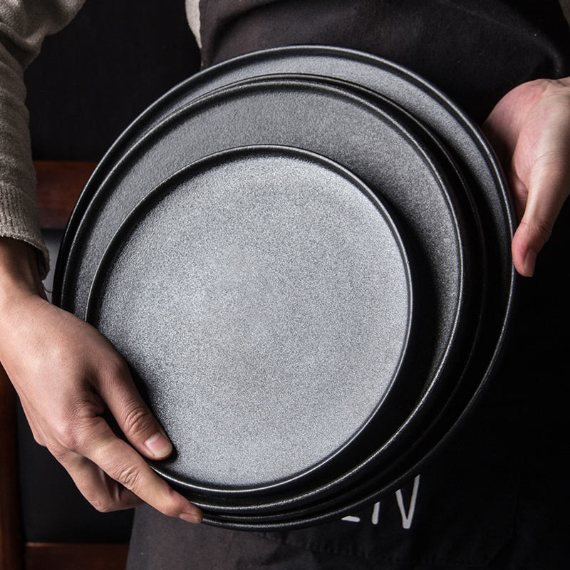 Stacked Matte Grey Ceramic Dinner Plates Held in Hands