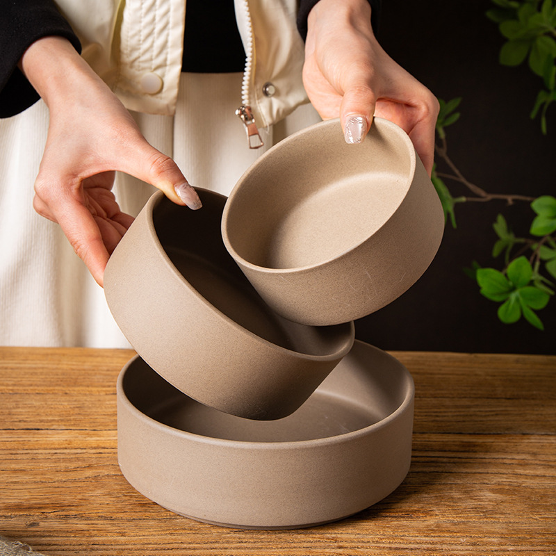 Taupe Matte Stacked Ceramic Bowls Being Arranged